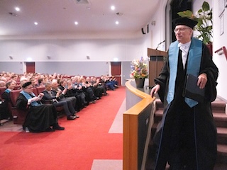 Prof.dr. Klinkert komt met applaus van podium na zijn afscheidscollege.